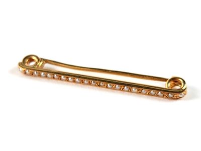 un gros plan d'une broche en or sertie de diamants sur fond blanc