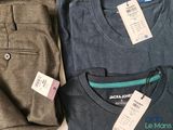 three pairs of men ' s pants and a t - shirt with a price tag