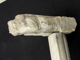 a stone carving of a head on top of a pillar