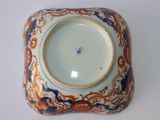 a blue and orange bowl on a white surface
