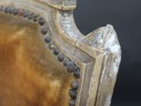 a close up of a gold chair with a black background