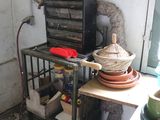a small kitchen with a stove and many pots and pans on the counter