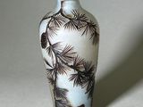 un vase blanc orné d'un motif représentant un pin