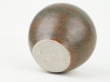 a close up of a brown and white ball on a white surface