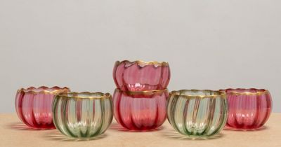 six verres roses et verts posés sur une table en bois