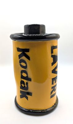 un gros plan d'une bobine de pellicule Kodak posée sur une surface blanche