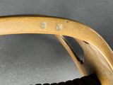 a close up of a wooden chair with a black seat