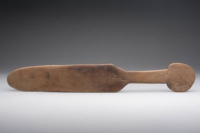 an old wooden paddle with a wooden handle on a white surface