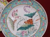 two plates with flowers and birds on them on a red surface