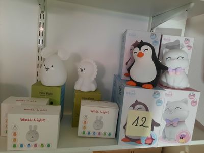 une étagère sur laquelle sont posés tout un tas de peluches et de boîtes