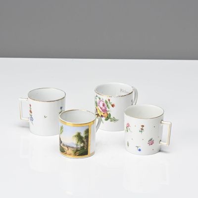 four coffee cups with floral designs on them sitting on a table
