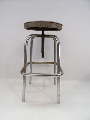 une image représentant un tabouret en métal avec une assise en bois, sur fond blanc