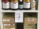 de nombreuses bouteilles de liquide posées sur une étagère à côté de cartons