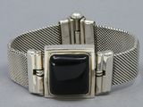 a close up of a silver bracelet with a black stone on it