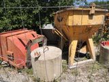 un camion-benne jaune derrière une clôture, à côté d'un conteneur à ciment