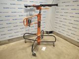 une paire de ciseaux orange posée sur un support métallique devant un mur