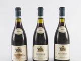 three bottles of wine sitting next to each other on a white surface