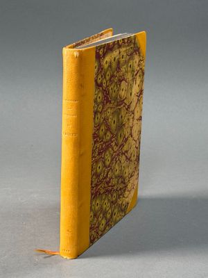 un vieux livre à la couverture jaune posé sur une table