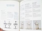 a person holding a book open to a page with pictures of silverware