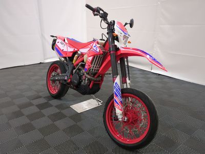 a red dirt bike that is parked on the floor