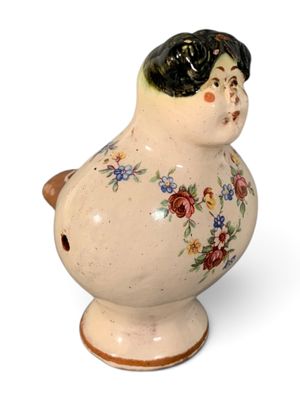 un petit vase orné d'une femme, posé sur un fond blanc