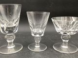 three clear wine glasses sitting on top of a table next to each other