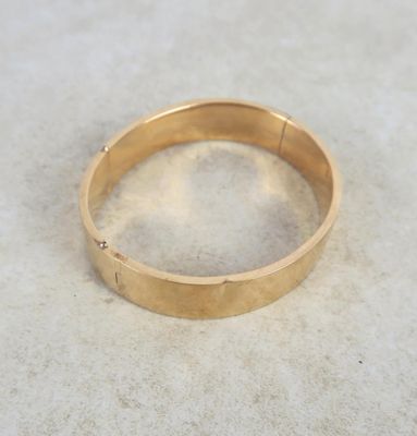 a close up of a gold ring on a white surface