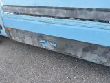 a blue truck that is parked on the side of the road