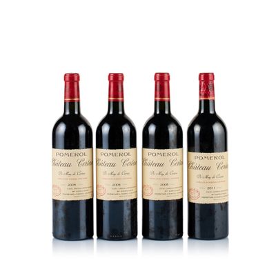 trois bouteilles de vin rouge posées l'une à côté de l'autre sur une surface blanche