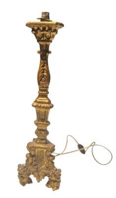 une image représentant une lampe de couleur dorée à laquelle est attaché un cordon