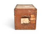 an old brown suitcase with a tag on it