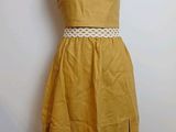 yellow dress on a mannequin stand against a white wall