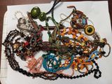 un tas de perles et de colliers de toutes sortes posés sur une table