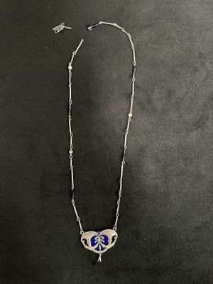 un gros plan d'un collier orné d'un papillon, posé sur une surface noire
