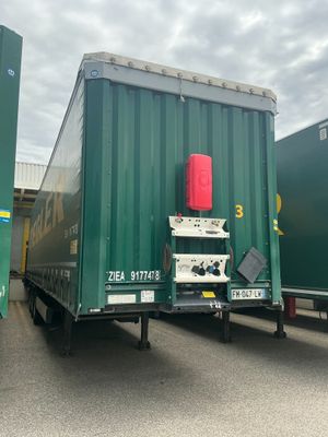 deux semi-remorques verts garés l'un à côté de l'autre sur un parking