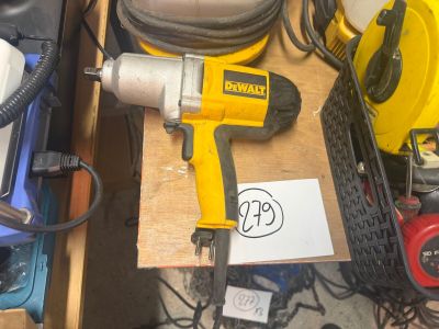 une perceuse jaune et noire posée sur une table, à côté d'autres outils