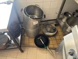 il y a beaucoup de casseroles et de poêles par terre dans la cuisine