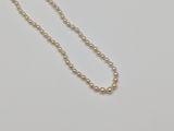 a close up of a pearl necklace on a white surface