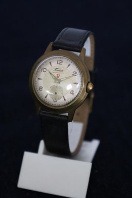 a watch that is sitting on a stand on a black surface