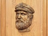 plaque en bois représentant un homme barbu coiffé d'un chapeau