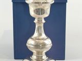 a silver candle that is sitting in front of a blue box