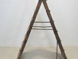 a wooden ladder that is leaning up against a wall