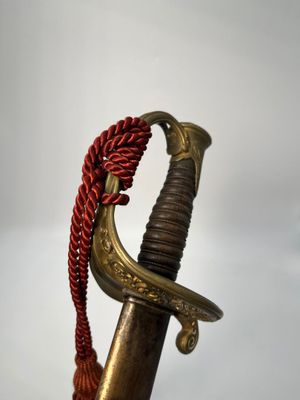 an old sword with a red rope hanging from it ' s end
