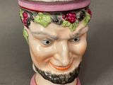 a ceramic cup with a man ' s face painted on it