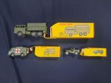 trois véhicules militaires miniatures sont alignés sur une surface bleue