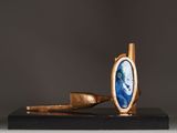 a close up of a sculpture of a pipe and a blue stone