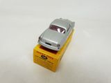 silver toy car sitting on top of a yellow box on a white surface