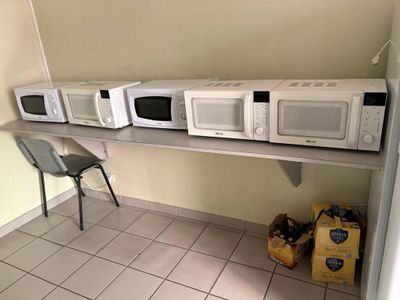 de nombreux micro-ondes posés sur une étagère dans une pièce
