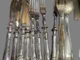 a lot of silverware on a table with a knife and fork