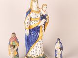 three figurines of a woman holding a child and a dog